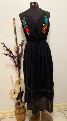 Introducing our Black Long Halter Embroidered Dress - the perfect combination of effortless style and intricate detail! This gorgeous dress features a flattering halter neckline and beautiful, colorful embroidery that pops against the classic gauze black fabric. The long, flowing silhouette gives you a graceful look while ensuring comfort and ease of movement. Whether you're headed to a special event, a summer evening gathering, or just want to feel extra stylish, this dress is a must-have. The unique embroidery adds a touch of culture and charm, making it both eye-catching and elegant. Step out in style with the Black Long Halter Embroidered Dress - your go-to for any occasion where you want to feel confident, comfortable, and chic! Size: Medium/Large Bustline: 37" all around elastic wais Hand Embroidered Dress, Mexican Embroidered Dress, Colorful Embroidery, Unique Embroidery, Dress Handmade, Summer Evening, Halter Neckline, Embroidered Dress, Dress Clothes For Women