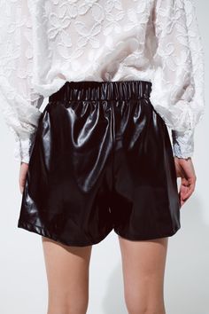 Add a touch of edgy sophistication to your wardrobe with our Black Faux Leather Shorts. These shorts are the perfect choice for a variety of occasions, combining style and comfort effortlessly.    With a short length and a standard fit, these shorts offer a classic and versatile look. The straight cut and faux leather material give them a sleek and stylish appearance, perfect for parties and more. Plus, they come with the convenience of pockets and a comfortable elastic waistband.    Crafted fr