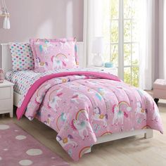 a bedroom with pink walls, white furniture and a unicorn comforter on the bed