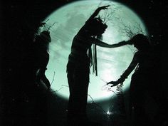 the silhouettes of two people dancing in front of a full moon