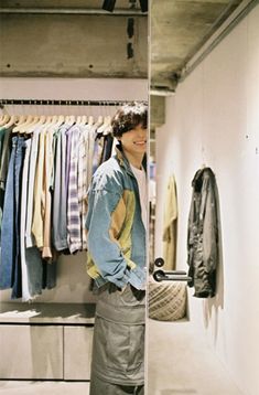 a man standing in front of a closet full of clothes