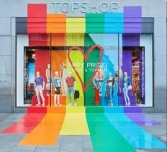 a rainbow colored shop front with mannequins in the window