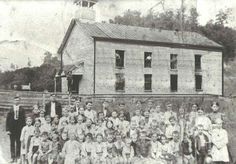 an old black and white photo of people in front of a building