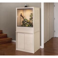 a tall white cabinet with an aquarium in the middle and stairs leading up to it