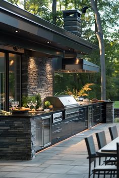 an outdoor kitchen with grill and dining table