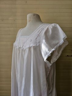 "Vintage nightgown. Made by Barbizon. Size large. Creamy white color. Short sleeves. Lace trims. Pleated detail. Square neckline. Embroidered. Floral rosettes. Long, midi ankle length. So dreamy and romantic! 65% polyester, 35% cotton. (measurements taken flat) Label size: Large Bust: 24\" Waist: 29\" Hips: 30\" Length: 43.5\" Shoulder width: 15\" Sleeve length: 6\" Excellent vintage condition. No rips, holes, or stains." White Short Sleeve Nightgown For Bedtime, Cottagecore White Nightgown For Home, White Cottagecore Nightgown For Home, White Cottagecore Nightgown, White Broderie Anglaise Nightgown For Sleep, White Short Sleeve Sleepwear With Ruffles, White Cottagecore Sleepwear With Lace Trim, Cottagecore White Sleepwear With Lace Trim, White Cottagecore Nightgown For Spring