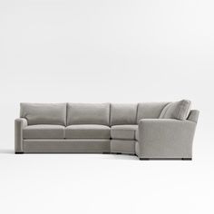 a grey sectional couch sitting on top of a white floor