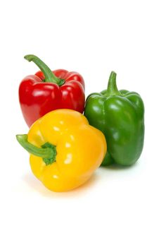 three different colored peppers sitting next to each other on a white surface with one pepper in the foreground