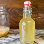 a glass bottle filled with liquid sitting on top of a counter