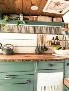 a kitchen with green cabinets and wooden ceiling