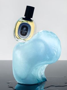 a bottle of cologne sitting on top of an iceberg