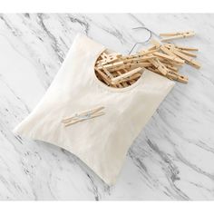 clothes pins and t - shirt on top of a white marble table with wooden clothes pins sticking out of it