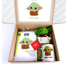 an open box containing items for star wars including books and stuffed toy yoda doll