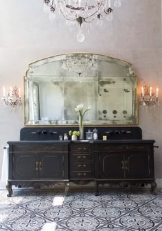 a fancy bathroom with chandelier and double sinks