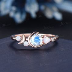 an image of a ring with opal and white stones on the inside of it