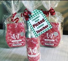 three packaged items on a table with red ribbon and tags attached to the bottles for each item