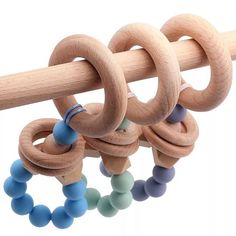 three wooden rings hanging from a rod with blue and green beads on each one side