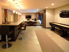 a room that has a pool table and some stools in front of the bar