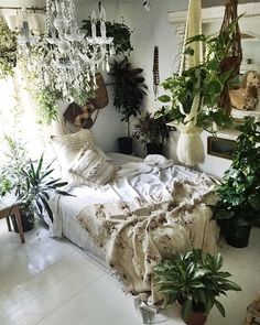 a bedroom with plants and chandelier hanging from the ceiling