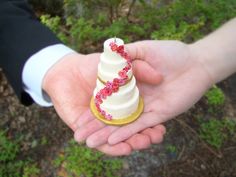 two hands holding a small white cake with red sprinkles on it and the words i love you