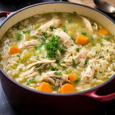 a red pot filled with chicken and rice soup