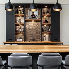 a bar with stools and lights above it