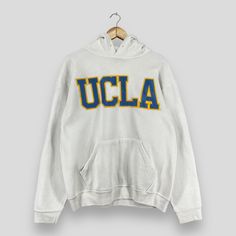 "REMINDER: THIS IS USED CLOTHING PLEASE DO NOT EXPECTED IT LIKE TO BE NEW OR IN PRISTINE CONDITION Feel free to contact me for any question. I'll assist you with my pleasure. Vintage UCLA Pullover Hoodie Large 1990's University Of California Spellout Embroidery Sportswear Sweater Ucla White Hoodie Sweater Size L *All measurements are taken with the garment flat on the ground. SIZE ON TAG :- Size L ACTUAL SIZE MEASUREMENT :- ARM PIT TO ARM PIT :- 23\" inches BACK COLLAR TO HEM :- 26\" inches CONDITION :- GREAT USED CONDITION. NO HOLES AND STAINS. ** WE ARE USING DHL EXPRESS, IT TAKES 3-5 WORKING DAYS ONLY TO ARRIVE. PLEASE LEAVE YOUR PHONE NUMBER ON THE NOTE WHILE MAKE A PURCHASE** REF : (13-01-2021) 888" Ucla Hoodie, Vintage Hoodie With Letter Print, College Hoodie With Double-lined Hood And Crew Neck, College Crew Neck Hoodie With Double-lined Hood, Vintage College Sweatshirt With Embroidered Logo, Vintage Sweatshirt With Embroidered Logo For College, Collegiate Sweatshirt With Double-lined Hood, Vintage Embroidered Logo Sweatshirt For College, Varsity Crew Neck Sweatshirt With Double-lined Hood