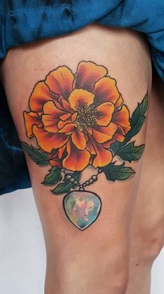 a woman's thigh with an orange flower on it and a heart in the middle