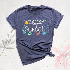 the back to school t - shirt is next to flowers