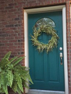 a green door with a wreath hanging on it's side and an instagram page below