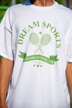 Join the Catford tennis club with our fun addition to the best selling Dream Sports collection. 100% heavyweight cotton t-shirt with front print and back prints Model is 5'11''/ 180cm and wearing a size x-large. Relaxed fit. Order the size you would usually wear. Size up if you are between sizes or would like an oversized fit. For a regular fit: 6/8- small, 10- medium, 12- large, 14- x-large. Free stickers included in every order We have a 30 day no hassle return policy Although we aim to ship all orders the same or next working day, please allow up to 2 working days for your order to be shipped as we make everything to order Washing instructions: 30 wash with similar colours, Reshape while damp, Do not iron print, Tumble dry medium, Do not bleach Tennis Graphic Tee With Crew Neck, White Graphic Tee For Tennis, Cotton Graphic Tee For Tennis, Green Graphic Print Tennis Tops, Cotton Letter Print T-shirt For Tennis, Sporty Letter Print T-shirt For Tennis, Green Casual Tennis T-shirt, Sporty Tennis T-shirt With Letter Print, Crew Neck Tennis T-shirt With Letter Print