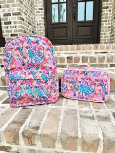 two pink and blue suitcases sitting on the steps