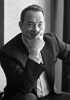 a black and white photo of a man in a suit with his hand on his chin