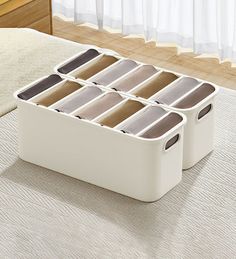 a white storage box on the floor with six compartments