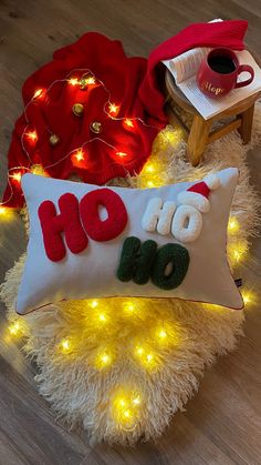 a christmas pillow with the words ho hoo on it next to a coffee mug