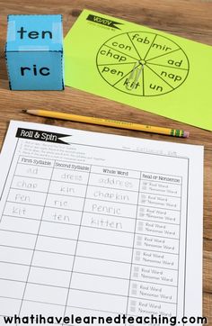 two pieces of paper sitting on top of a wooden table next to pencils and markers