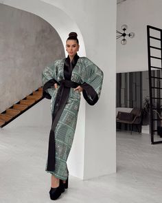 This oriental print long kimono robe showcases a stunning green bohemian kimono design with intricate, traditional patterns in rich shades of green, white, and black. The robe's wide, flowing bell sleeves and solid black satin trim add a touch of elegance to the overall silhouette. This maxi silk women bathrobe drapes beautifully, offering both comfort and luxury. Ideal as elegant nightwear, this robe combines style and sophistication, making it perfect for special occasions or lounging in refin Luxury Black Long Sleeve Robe, Elegant Green Maxi Kimono, Elegant Green Wrap Kimono, Elegant Green Maxi-length Kimono, Elegant Long Green Kimono, Bohemian Maxi Dress With Kimono Sleeves For Evening, Bohemian Evening Kaftan With Kimono Sleeves, Evening Bohemian Kaftan With Kimono Sleeves, Evening Kaftan With Kimono Sleeves