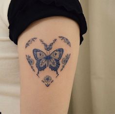 a heart shaped tattoo with a butterfly on the back of it's arm,