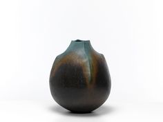 a black vase sitting on top of a white table