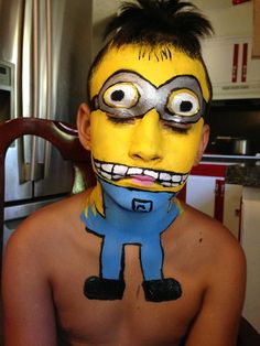 a young boy with his face painted like a minion