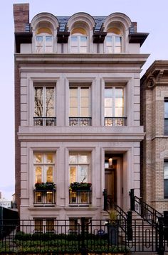 an apartment building with many windows and balconies on the second floor, along with wrought iron railings