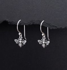 A pair of sterling silver earrings featuring teeny tiny bee charm dangles. Earring closure options: French hook ear wire with ball end or leverback. Approximate height from top of ear wire to bottom 1". Bee Height From Top to Bottom 12mm Bee Width at Widest Point 12mm Earring Closure Hook Ear Wires or Leverback Metal Sterling Silver Color Sterling Silver Metal Purity 925 Production Time 2-3 Business Days Honey Bee Earrings, Bee Earrings, Bee Charms, Dangle Charms, Silver Pieces, Nature Jewelry, Earrings Sterling Silver, Honey Bee, Ear Wire