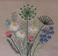 the embroidery is done with different colors and designs on it, including daisies and other flowers