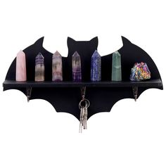 a bat shaped shelf with key chains hanging from it's sides