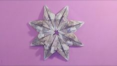 an origami star made out of money on a purple background