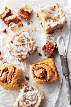 several cinnamon rolls on top of paper next to a fork