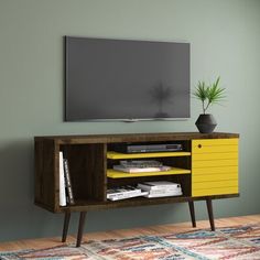 an entertainment center with yellow drawers and a television on the wall in front of it