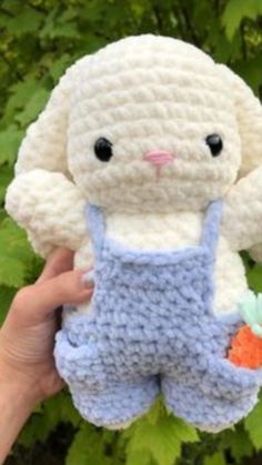 a crocheted bunny holding a carrot in its hand