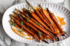 some carrots are on a white plate with sauce