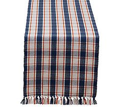 a plaid table runner with tassels on it